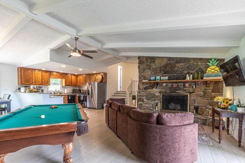 a living room with a pool table and a stone fireplace at Mountain Forest Manor in Hiawassee