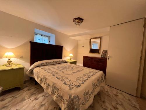 a bedroom with a bed and a dresser and a window at A casa do teléfono in Pumares