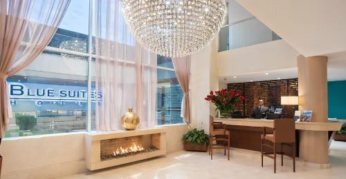 a hotel lobby with a fireplace and a chandelier at Blue Suites Hotel in Bogotá