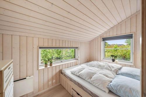 a bed in a room with two windows at FY416-Frorup-Engparken-10 in Frørup
