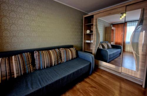 a living room with a blue couch and a chair at Omes puurs in Ventspils