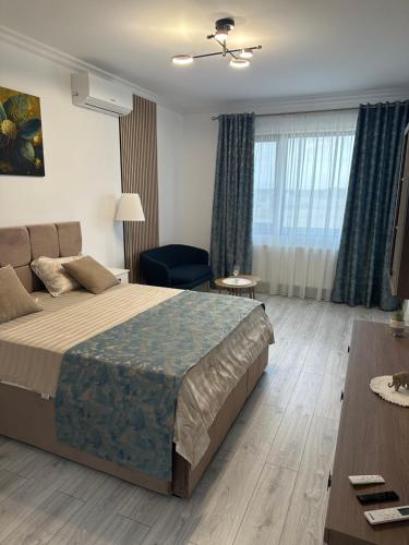 a hotel room with a large bed and a table at Day Studio in Focşani