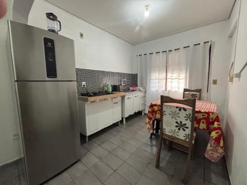 a kitchen with a stainless steel refrigerator and a table at Apto João-de-Barro in Rondonópolis
