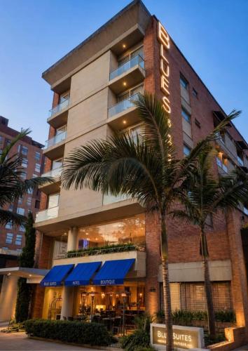 a hotel with a palm tree in front of it at Blue Suites Hotel in Bogotá
