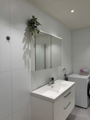 a white bathroom with a sink and a mirror at Leknestunet in Vestvågøya