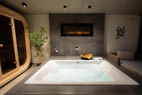 a large bath tub in a room with a fireplace at SAUERLAND CHALETS - "Die Chalets Lieblingsplatz" in Winterberg