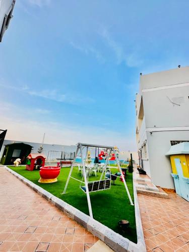 a yard with a playground with a swing at شقق ارين المصيف للشقق المخدومة in Al Hada