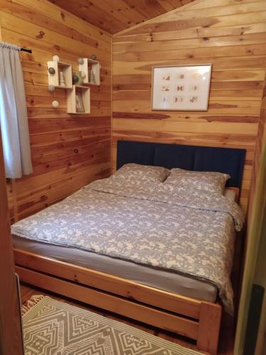 a bedroom with a bed in a log cabin at Sosnowy Domek in Wólka