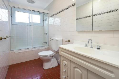 a bathroom with a toilet and a sink and a shower at The River House - Wisemans Ferry in Wisemans Ferry