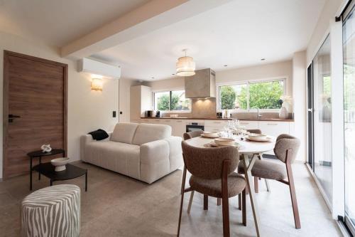 a living room with a table and a couch at L'Entre Nous Climatisation Terrasse in Saint Avre la Chambre