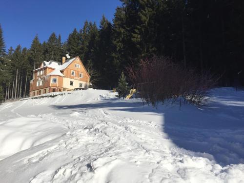 a house on top of a snow covered hill at Vila Eden in Pec pod Sněžkou