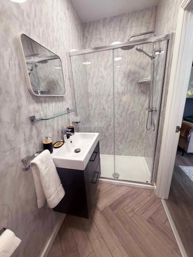 a bathroom with a shower and a white sink at Castle Mount Apartments in Sandal and Walton