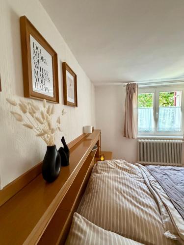 a bedroom with a bed and a vase of flowers at Ferienwohnung Lauterach in Lauterach