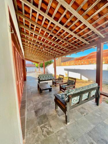 a porch with several beds under a wooden roof at Pousada Casa Atlântica in Luis Correia