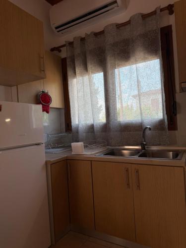 a kitchen with a sink and a refrigerator at Maronia Villa in Maronia