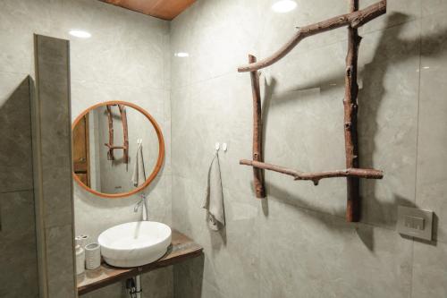 a bathroom with a sink and a mirror at The Wood Cabin in Ambarita