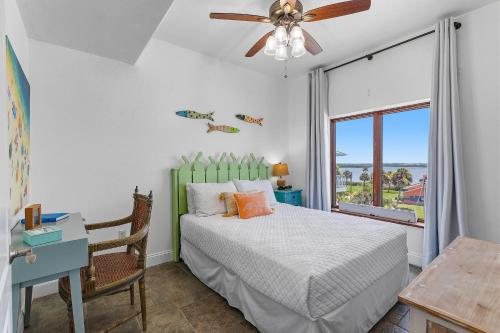 a bedroom with a bed with a ceiling fan and a window at Sea Manor in New Smyrna Beach