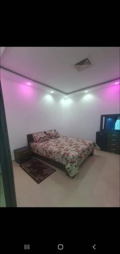 a bedroom with a bed in a room with purple lights at Location par nuitée in Oran