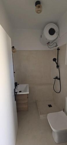 a bathroom with a white toilet and a sink at Syros Blue Lagoon G2 in Galissas