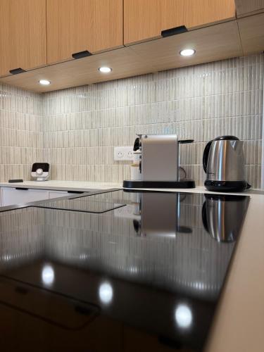 a glass counter in a kitchen with a coffee maker at Maison Gazel in Castres