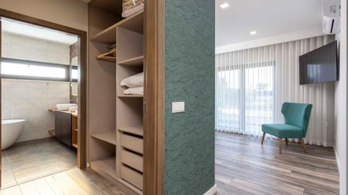 a walk in closet with a green chair in a room at Private Alvor villa with pool and Jacuzzi in Alvor