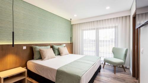 a bedroom with a large bed and a chair at Private Alvor villa with pool and Jacuzzi in Alvor