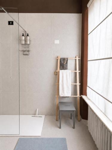 a bathroom with a shower and a bench next to a glass shower at Venzone dalla Finestra in Venzone