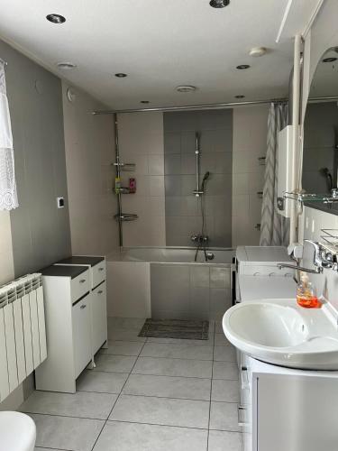 a white bathroom with a tub and a sink at U Leona in Przeciszów