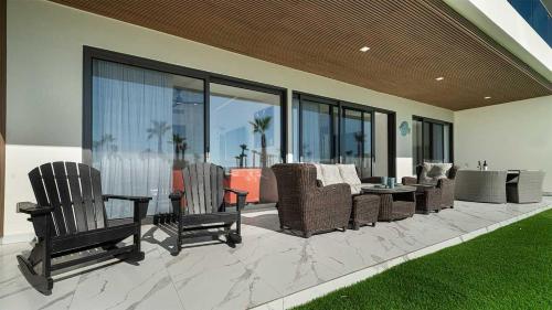 a patio with chairs and a table and windows at Encantame Soleil Ground Floor Getaway in Playa Encanto