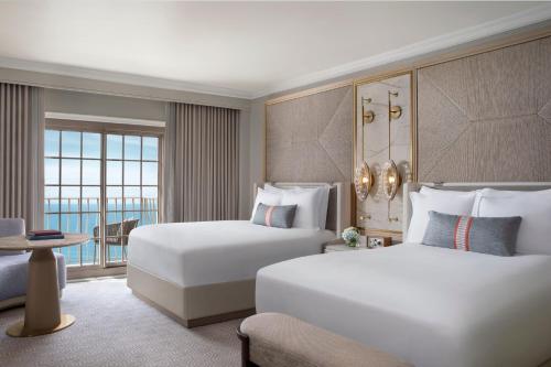 a hotel room with two beds and a balcony at The Ritz-Carlton Naples in Naples