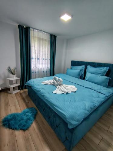 a bedroom with a blue bed with a towel on it at Cabana Tonea in Avrig