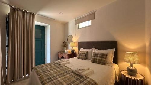 a bedroom with a bed with two towels on it at Provesende Douro Villas -Pateo Douro in Provesende
