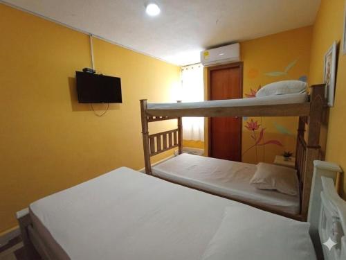 a bedroom with two bunk beds and a television at hotel habiby32 descansa in Barranquilla