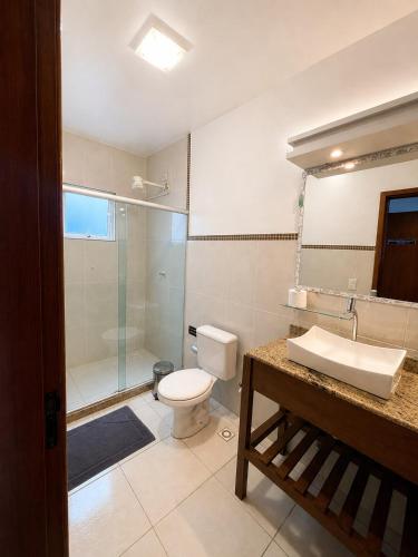 a bathroom with a toilet and a shower and a sink at Casa Estelar in Cabo Frio