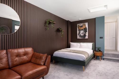 a bedroom with a bed and a couch and a mirror at Modern Studio Apartment with harbour views in Penzance