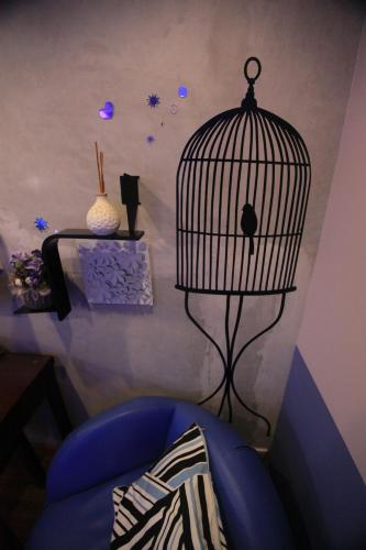 a room with a blue chair and a bird cage at Espace Elastique B&B with contactless check-in in Hong Kong