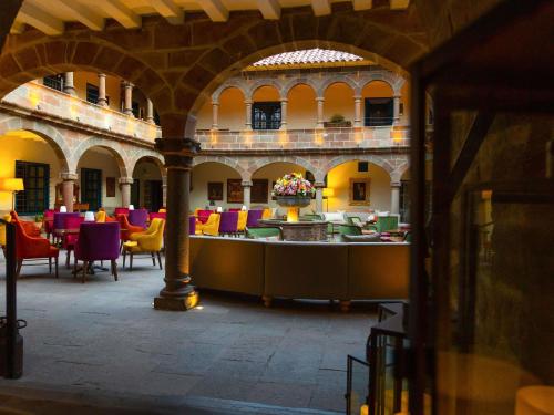 a room with colorful chairs and tables in a building at Novotel Cusco in Cusco