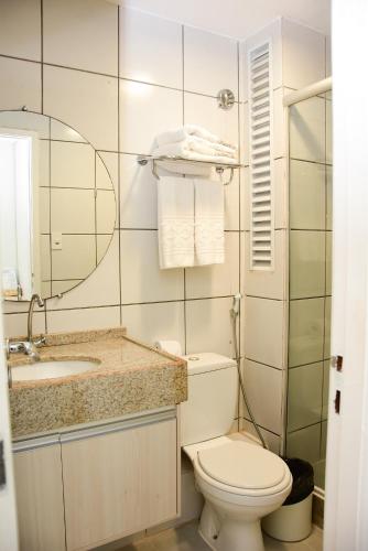 a bathroom with a toilet and a sink and a mirror at Grand Lençóis Flat in Barreirinhas