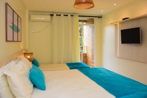 a bedroom with a bed with a television on the wall at Grand Lençóis Flat in Barreirinhas