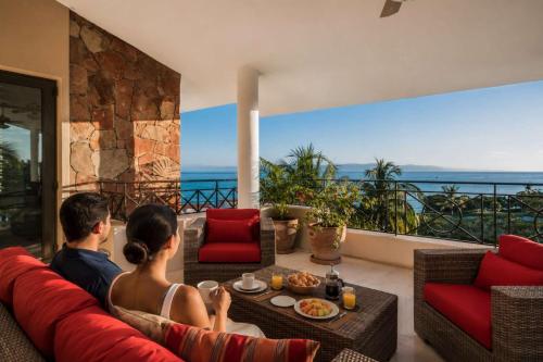 a man and woman sitting on a couch in a living room at Luxury Oceanview Penthouse in HDM in Punta Mita