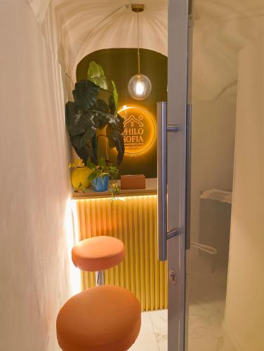 a stool in a room with a sign and plants at Philosofia in Naples