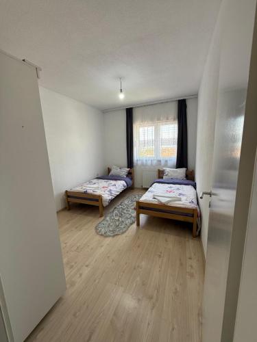 a room with two beds and a window at Unik Apartment in Kosovo Polje