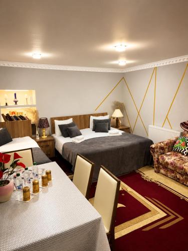 a hotel room with two beds and tables and a couch at Sheki Panorama Garden in Sheki
