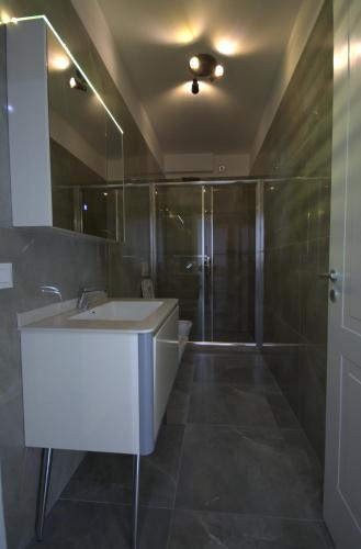 a bathroom with a white sink and a shower at Villa Lumi Mat in (( Mal i Kakariqit ))