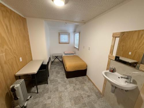 a small bathroom with a bed and a sink at Qt inntouch in Queenstown