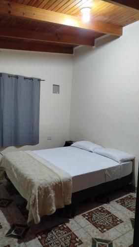 a bedroom with a large bed and a ceiling at La Reserva in Oberá
