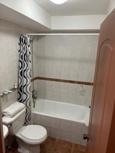 a bathroom with a tub and a toilet and a sink at DUNA Apart Hotel in Copiapó
