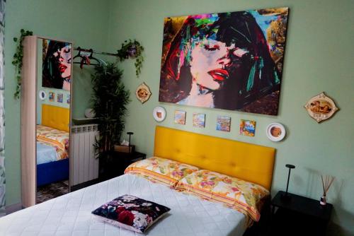 a bedroom with a bed and some pictures on the wall at Nice room with private bathroom in Ercolano