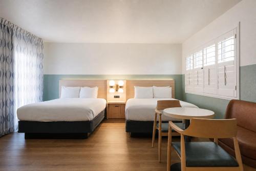 a hotel room with two beds and a table at Stargazer Hotel in Monterey