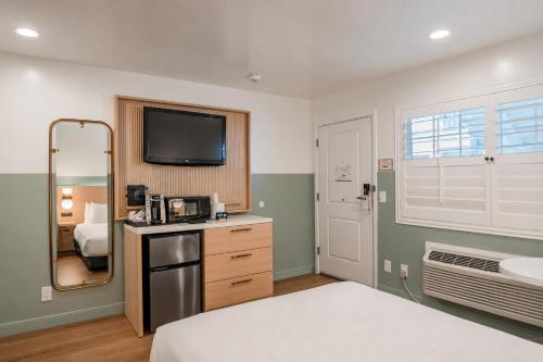 a bedroom with a bed and a tv on the wall at Stargazer Hotel in Monterey